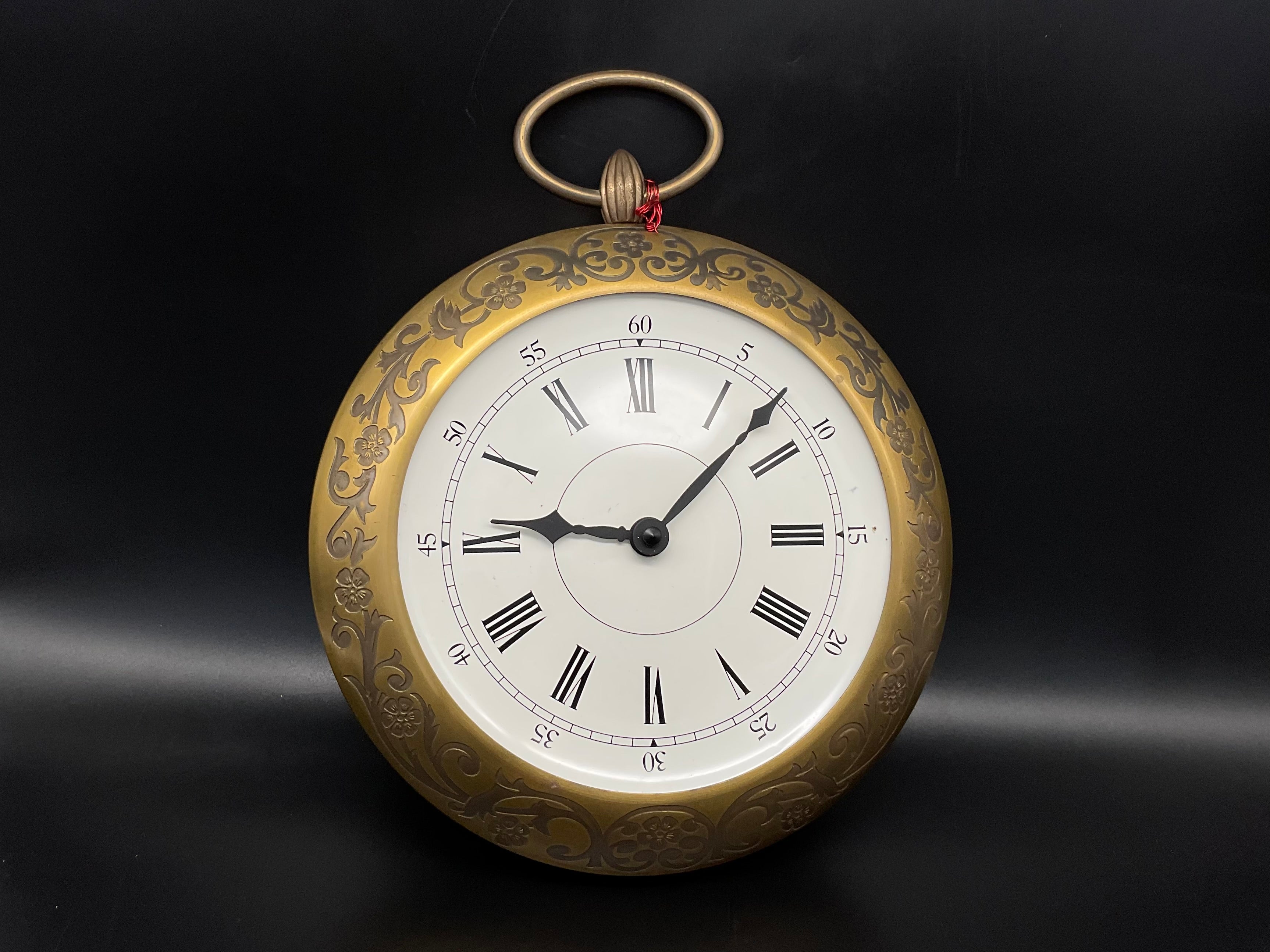 Goldfarbige Wanduhr mit Hänkel