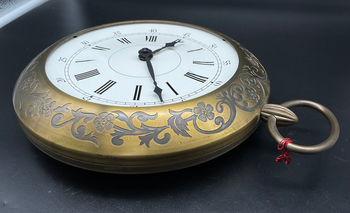 Goldfarbige Wanduhr mit Hänkel