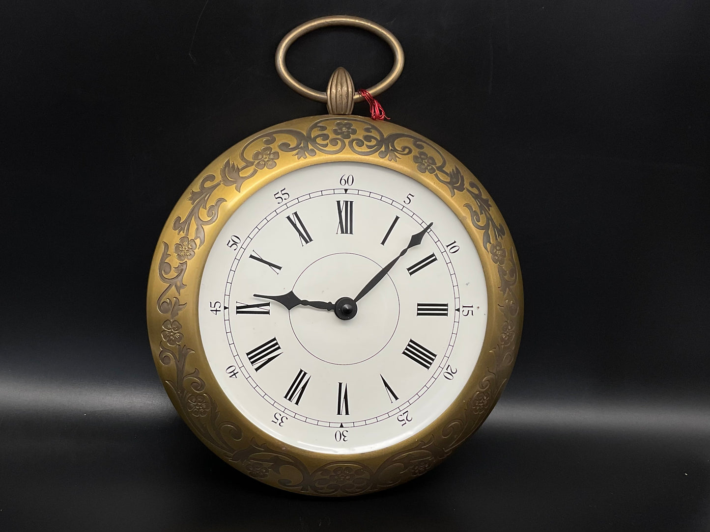 Goldfarbige Wanduhr mit Hänkel